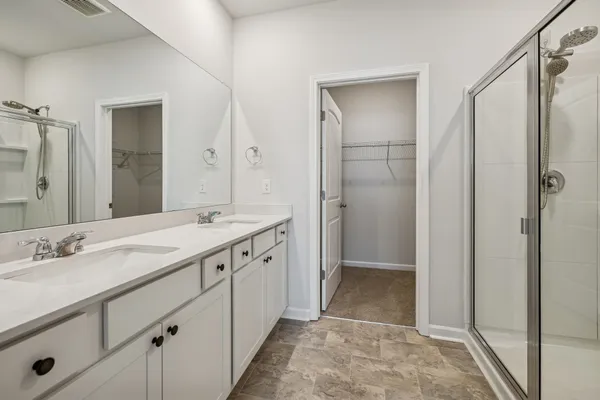 a spacious bathroom with a shower sink and mirror