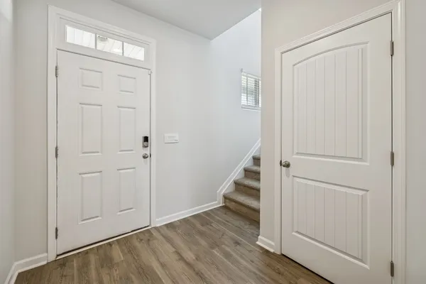 a view of a hallway with wooden floor and entryway