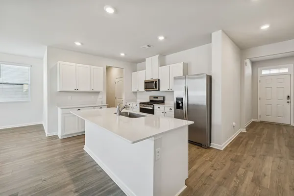 a large kitchen with stainless steel appliances refrigerator a microwave oven and cabinets