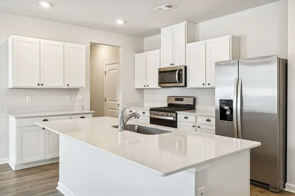 a kitchen with stainless steel appliances a refrigerator sink and microwave