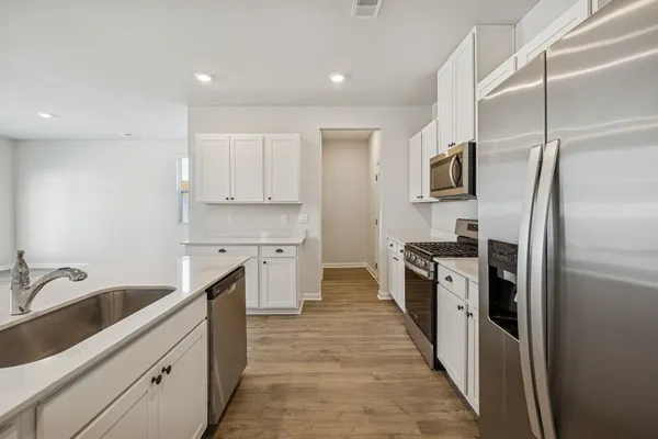 a kitchen with stainless steel appliances a sink stove and refrigerator