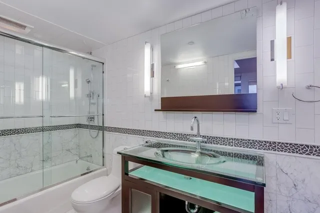a bathroom with a sink a toilet and shower