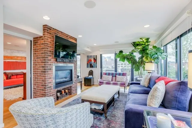 a living room with furniture a flat screen tv and a fireplace