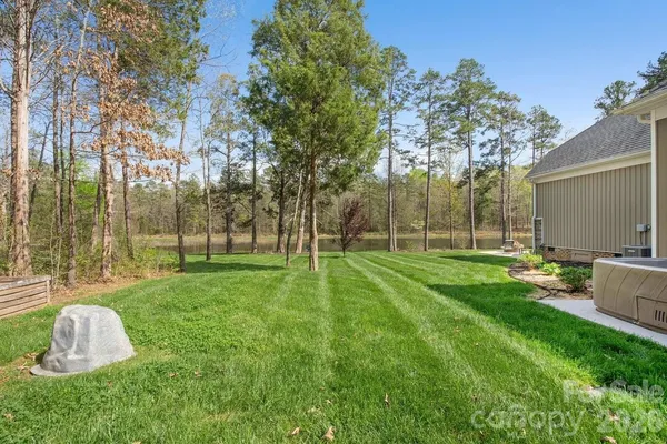 a view of backyard with table and chairs and a large tree