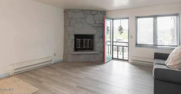 a view of a livingroom with wooden floor and a fireplace