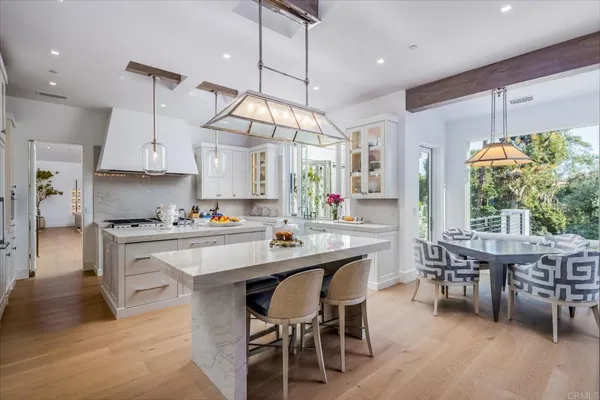 a kitchen with kitchen island granite countertop a table chairs sink and cabinets