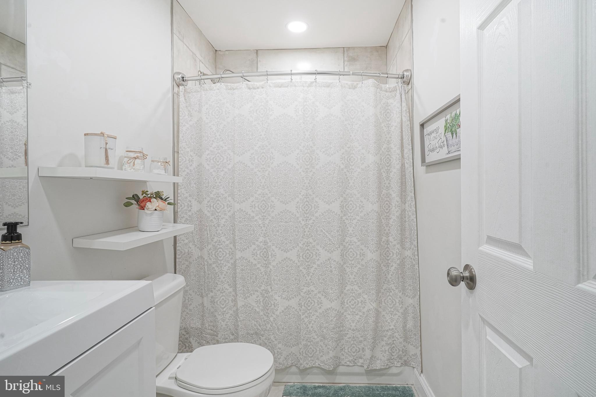 48 Memphis Court Sicklerville, NJ 08081 - Photo 22 of 28 a bathroom with a sink a toilet and shower curtain