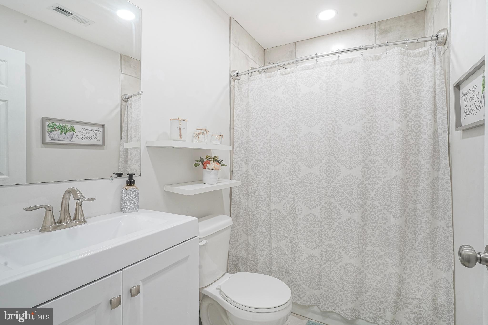 48 Memphis Court Sicklerville, NJ 08081 - Photo 23 of 28 a bathroom with a sink a toilet and shower curtain
