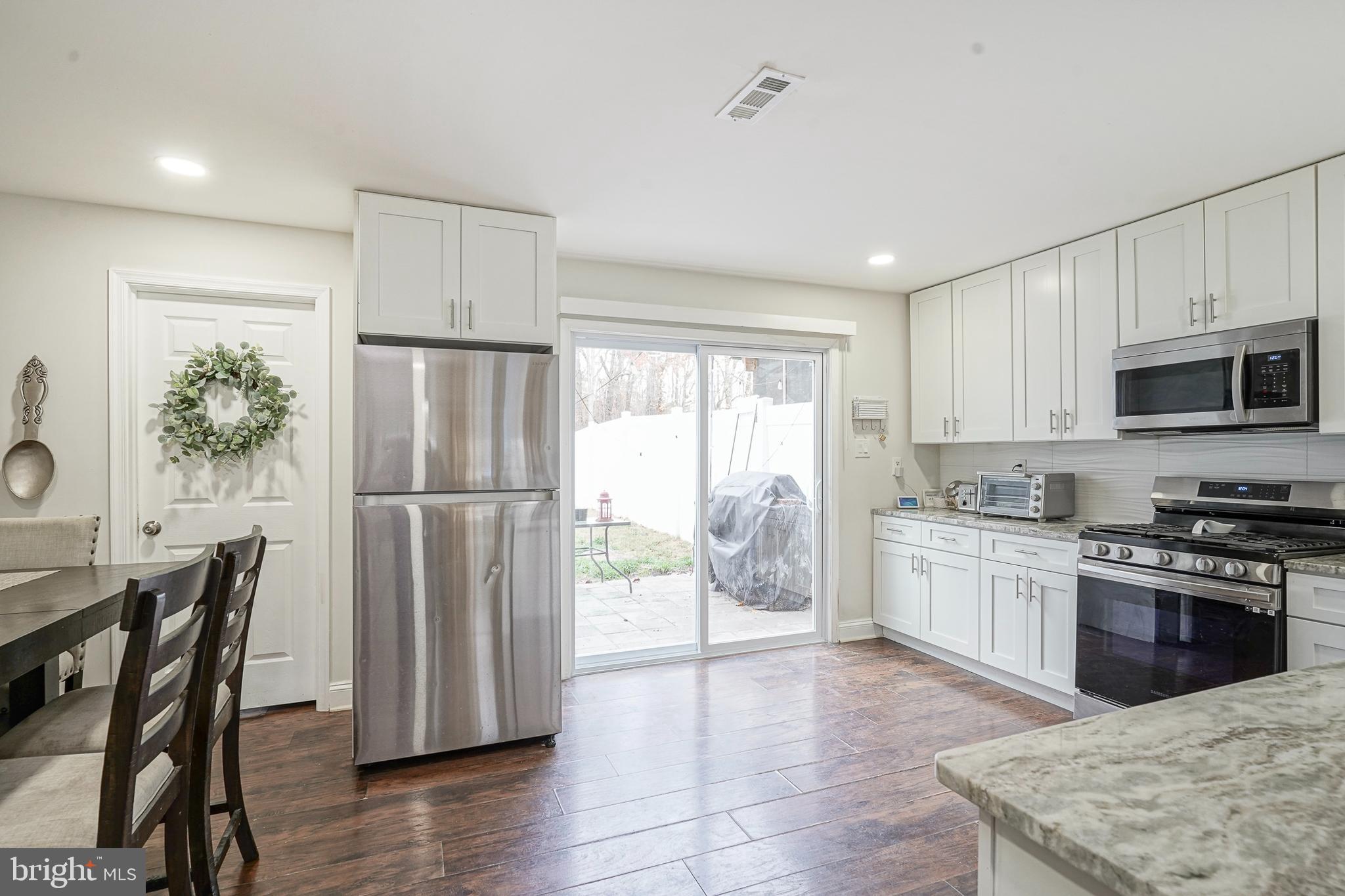 48 Memphis Court Sicklerville, NJ 08081 - Photo 8 of 28 a kitchen with stainless steel appliances granite countertop a refrigerator a stove top oven a sink dishwasher and white cabinets with wooden floor