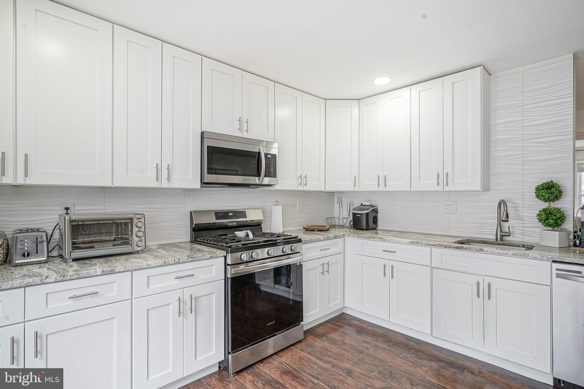 48 Memphis Court Sicklerville, NJ 08081 - Photo 10 of 28 a kitchen with cabinets stainless steel appliances a sink and wooden floor