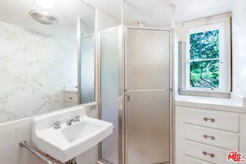 a bathroom with a sink a mirror and a shower