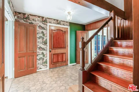 a view of front door with wooden floor and stairs