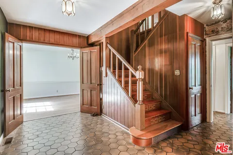 a view of a hallway with wooden floor and stairs