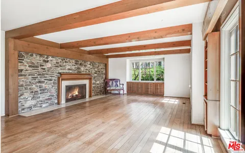 a view of a livingroom with wooden floor and a fireplace