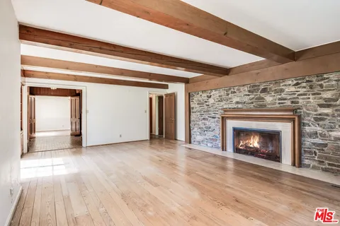 a view of empty room with wooden floor and fireplace