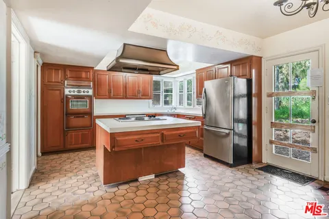 a kitchen with stainless steel appliances granite countertop a refrigerator and a stove
