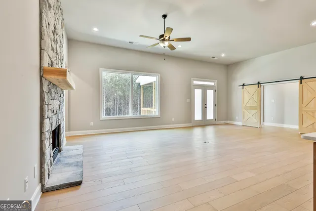 a view of an empty room with a window and fireplace