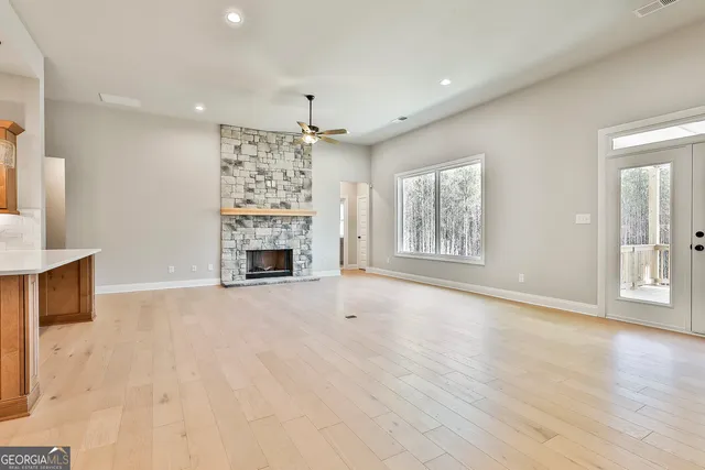 a view of an empty room with a fireplace and a window
