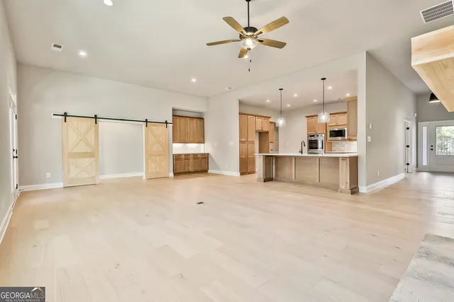 a large kitchen with kitchen island a sink stainless steel appliances and cabinets