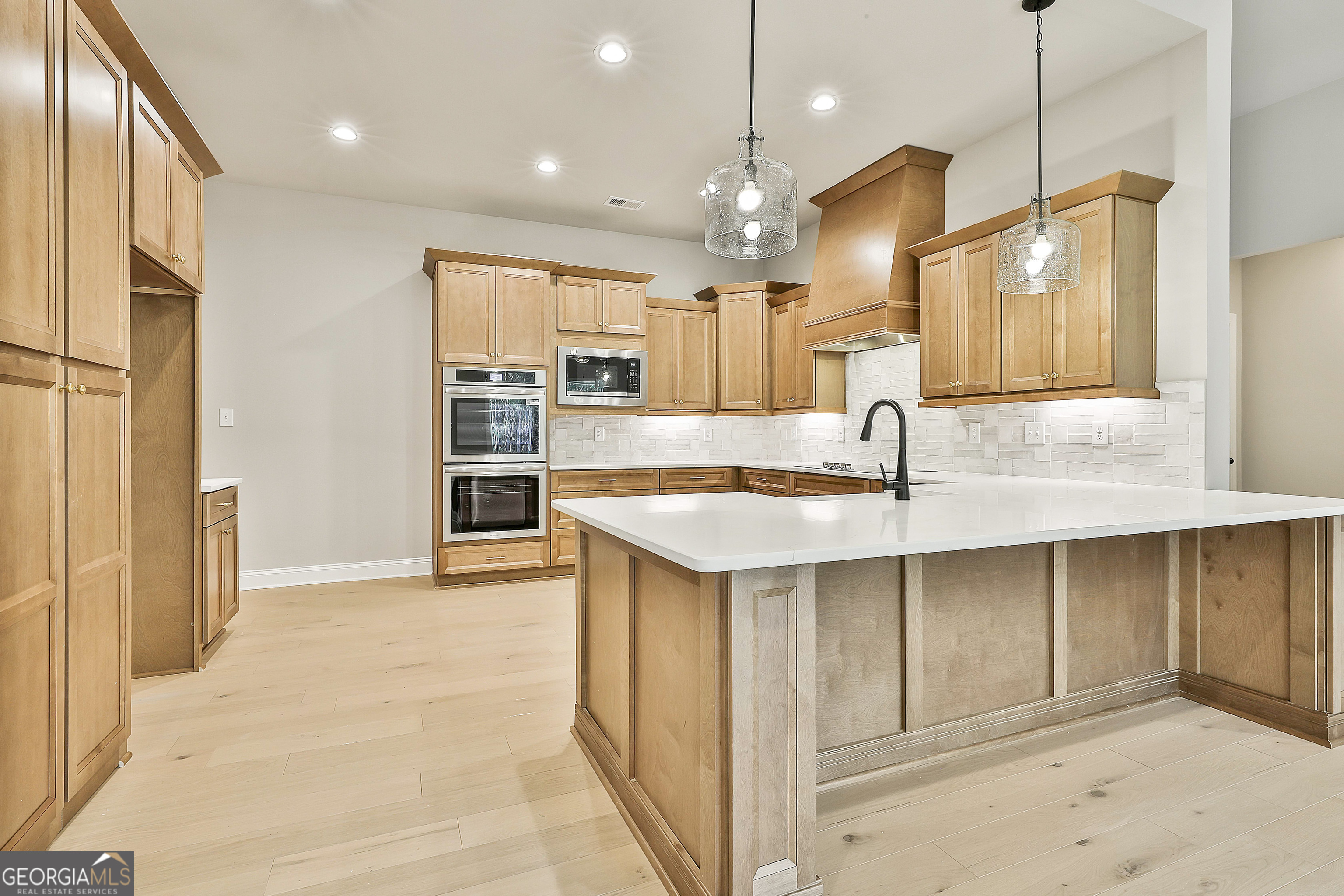 16 Nelson Way, Unit 38 Williamson, GA 30292 - Photo 20 of 44 a kitchen with kitchen island a sink stainless steel appliances and cabinets