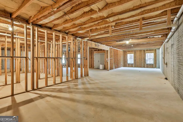 a view of an empty room with wooden floor and door