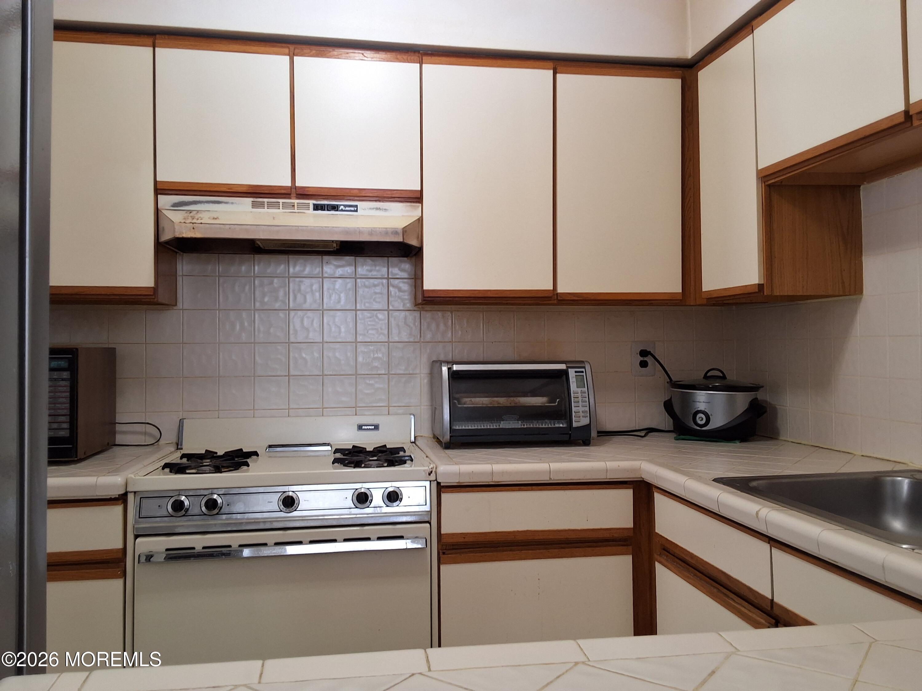 12 Coventry Court, Unit 12 Matawan, NJ 07747 - Photo 8 of 21 a kitchen with stainless steel appliances granite countertop a stove a sink and white cabinets
