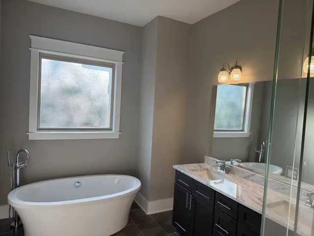 a view of a bathroom with a tub sink and mirror