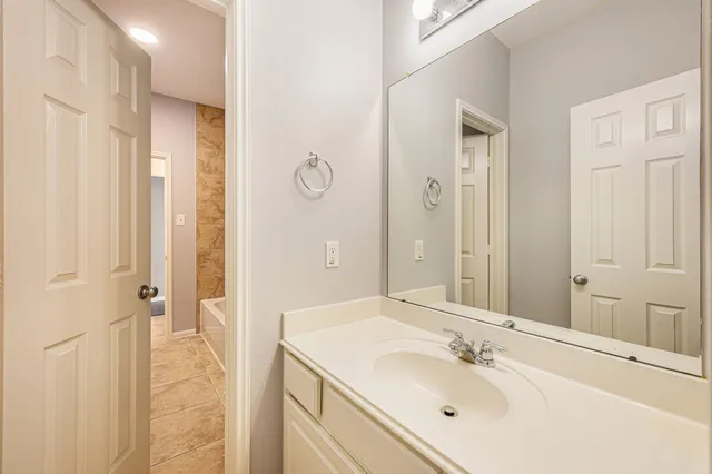 a bathroom with a sink a mirror a vanity and a shower