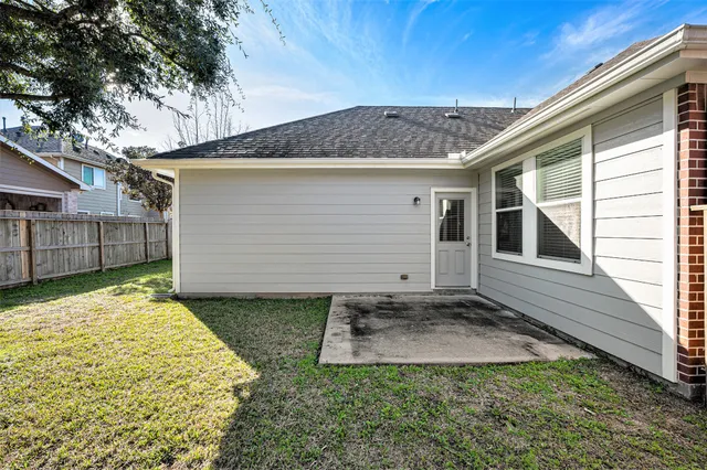 a view of a house with a small yard and wooden fence