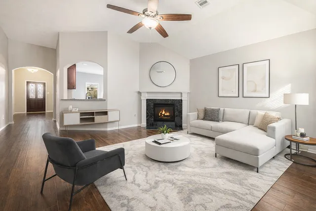 an empty room with windows fireplace and wooden floor