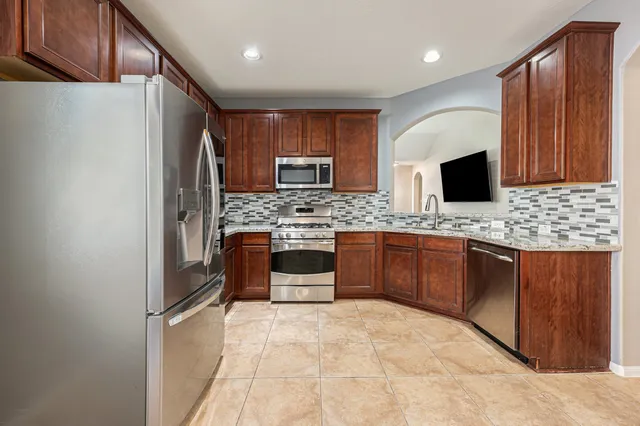 a large kitchen with a refrigerator and a stove top oven