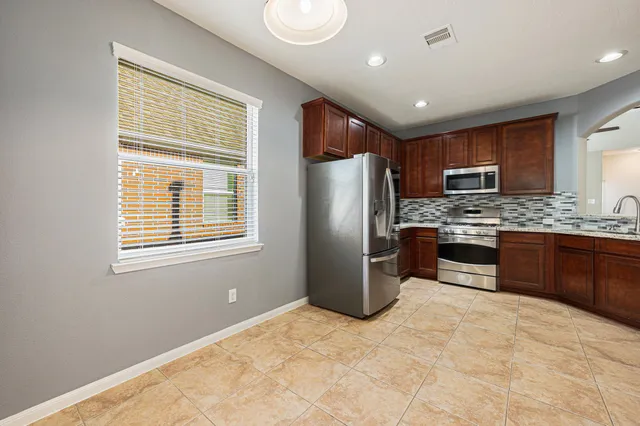 a kitchen with stainless steel appliances granite countertop a refrigerator stove and sink