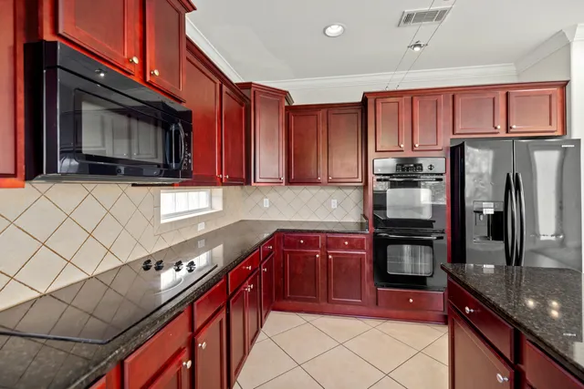 a kitchen with stainless steel appliances granite countertop a stove microwave and refrigerator