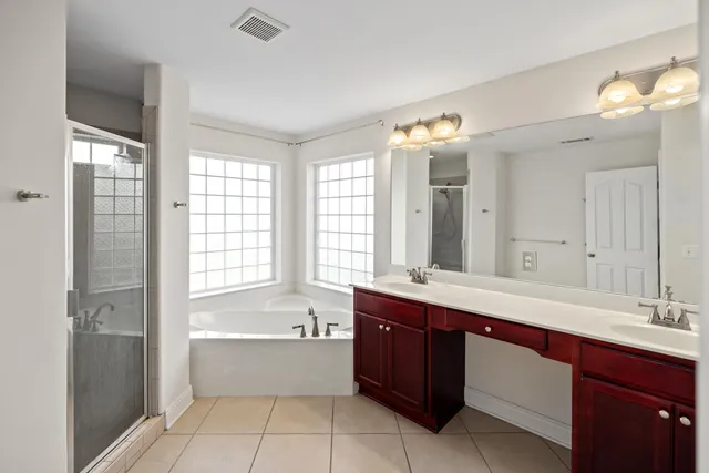 a bathroom with a tub sink shower and mirror