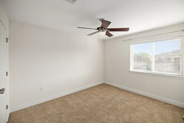 a view of a room with a window and a ceiling fan