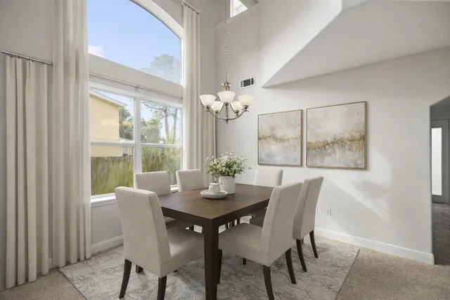 a view of a dining room with furniture a rug and wooden floor
