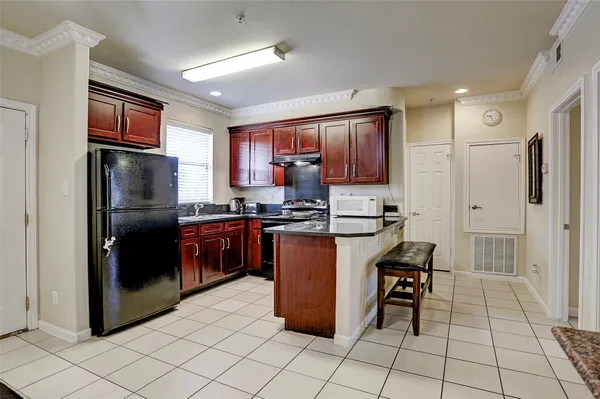 a kitchen with stainless steel appliances granite countertop a refrigerator and a stove top oven