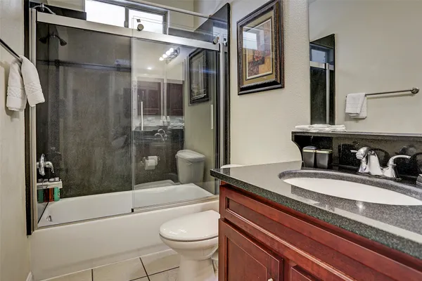 a bathroom with a granite countertop sink toilet and shower