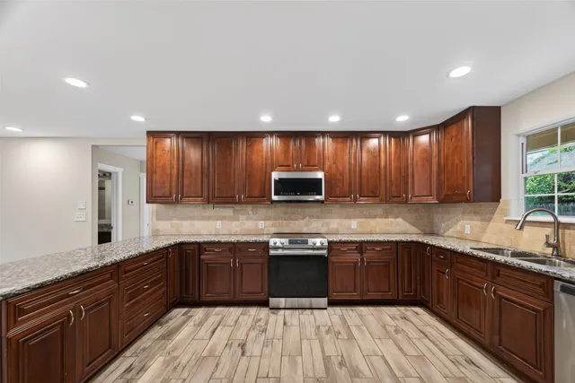 a large kitchen with wooden cabinets and stainless steel appliances