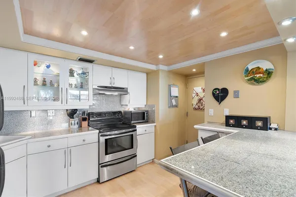 a kitchen with stainless steel appliances granite countertop a sink stove and cabinets