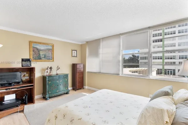 a bedroom with a bed and a large window with the outer view