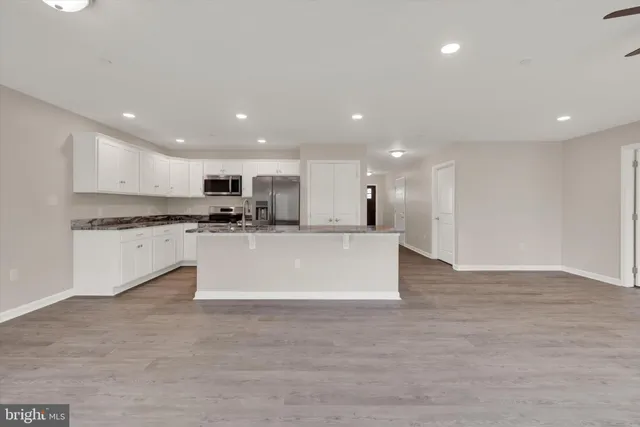 a large kitchen with stainless steel appliances granite countertop a large counter top and a stove top oven