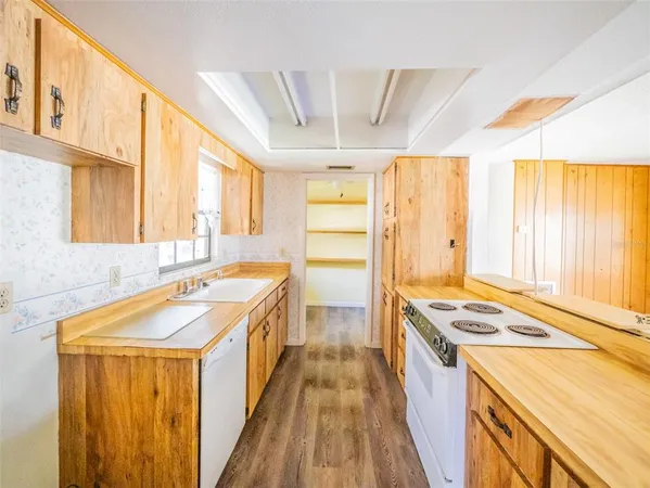 a kitchen with a stove a sink dishwasher and a refrigerator