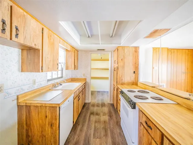 a kitchen with a stove a sink dishwasher and a refrigerator