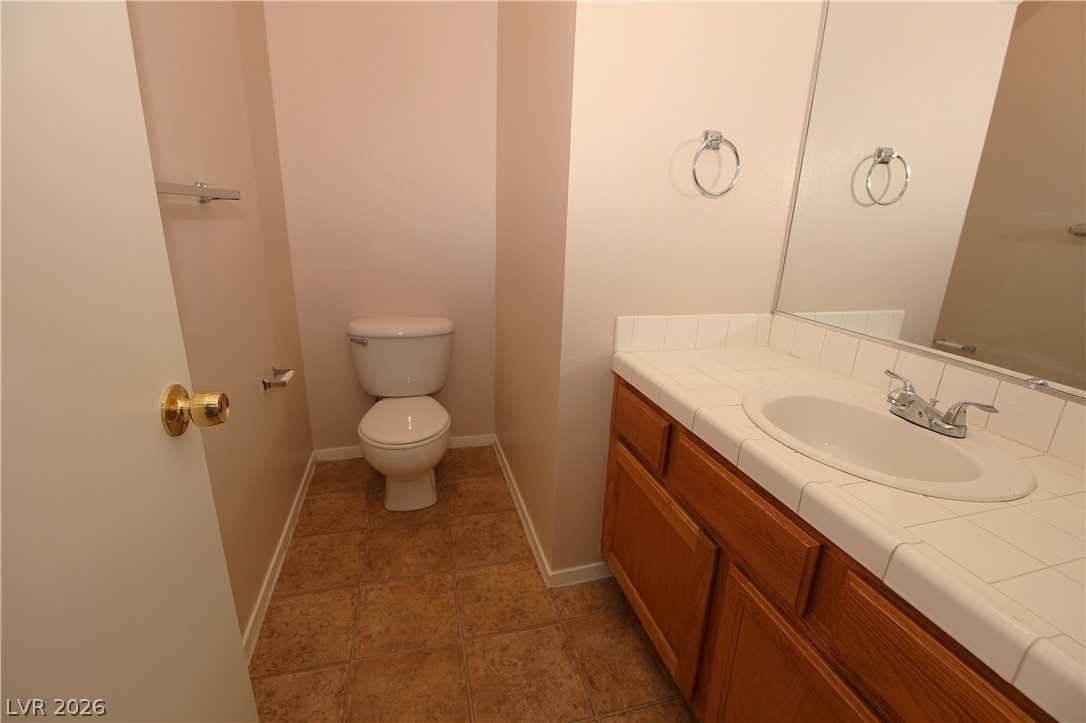 8220 Maplestar Road Las Vegas, NV 89128 - Photo 28 of 29 Functional full bathroom with a tiled vanity and an integrated sink.