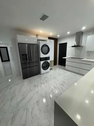 a kitchen with a sink and a stove with wooden floor
