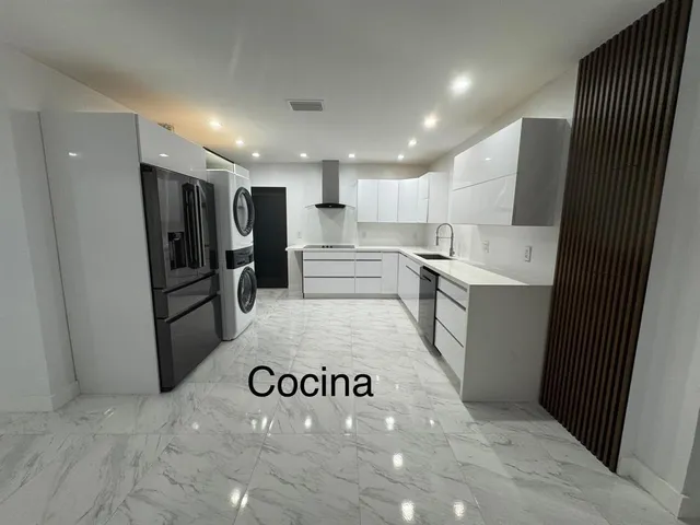 a kitchen with stainless steel appliances a sink dishwasher stove refrigerator and cabinets
