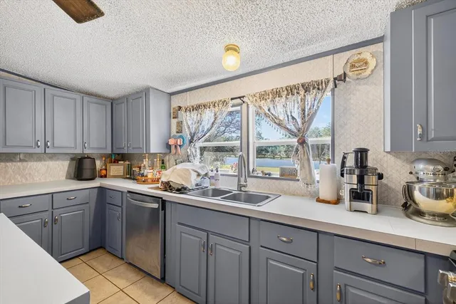 a kitchen with a sink a window and cabinets