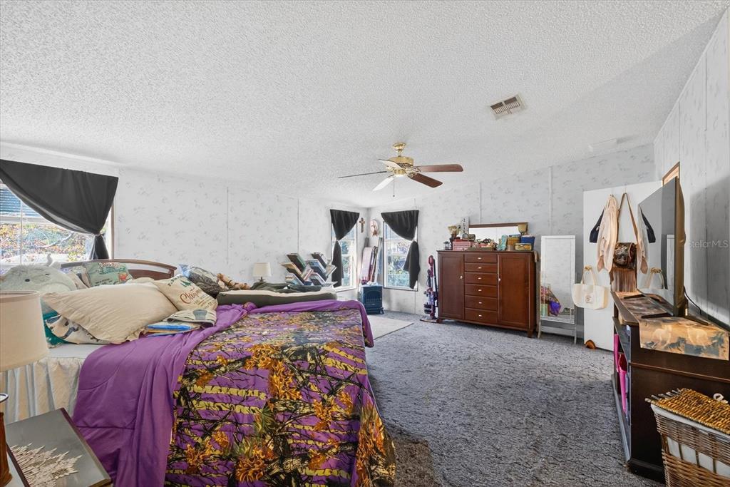 5280 Golddust Road Spring Hill, FL 34609 - Photo 19 of 41 a bed room with furniture and a flat screen tv