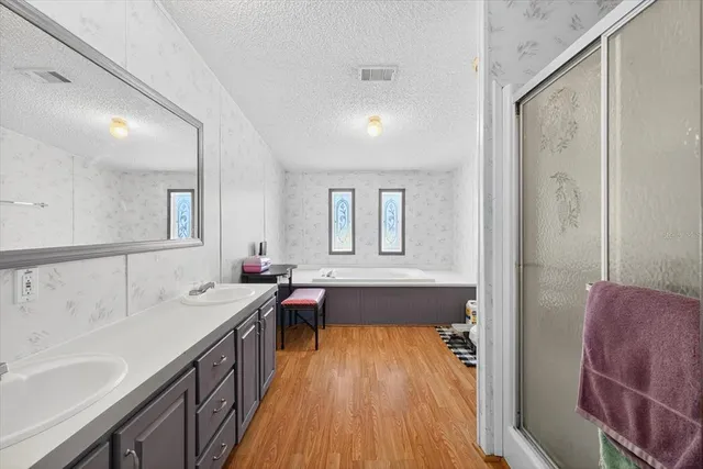 a spacious bathroom with a tub double vanity sink and a mirror